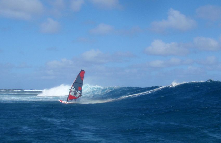 Windsurfer na deski z jadrom na visokih valovih na Mavriciju.